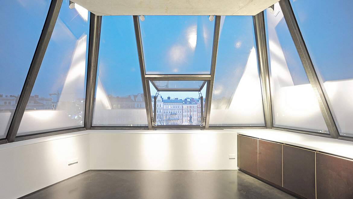 A light-filled attic with large glass elements and an open window.