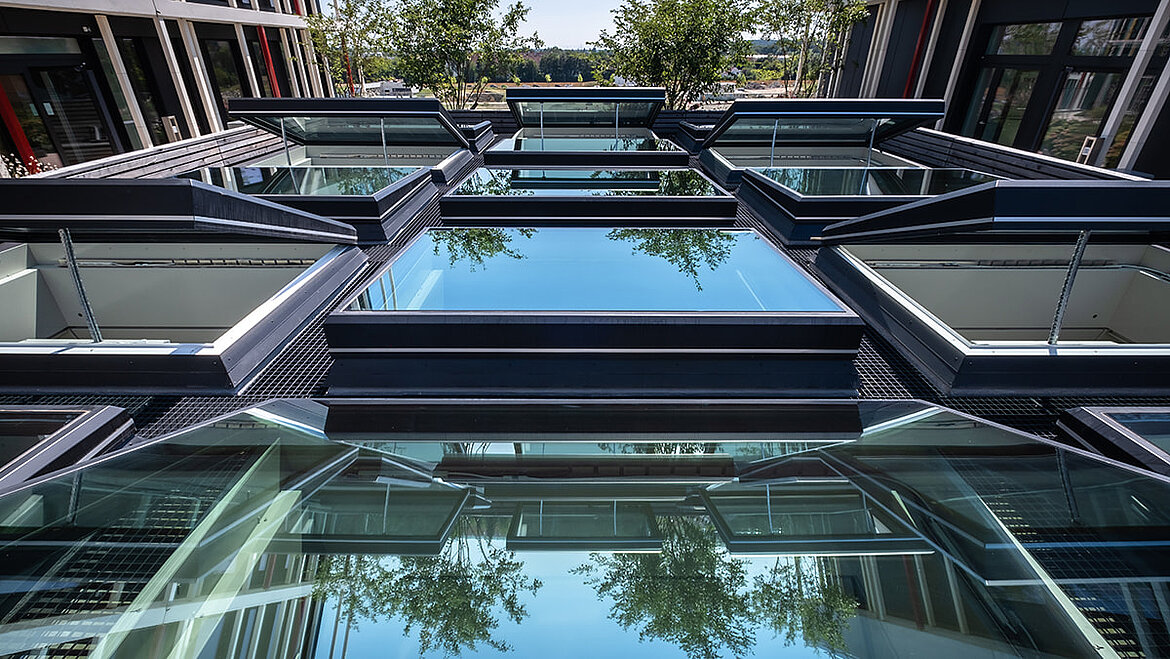 Modern glass roof construction with several open flat roof windows