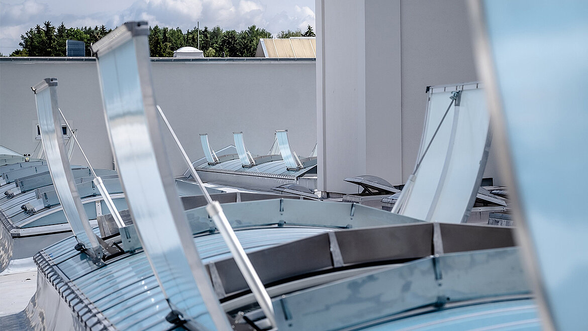 Several open Continuous Rooflights on the flat roof of a modern industrial building with aluminium frames