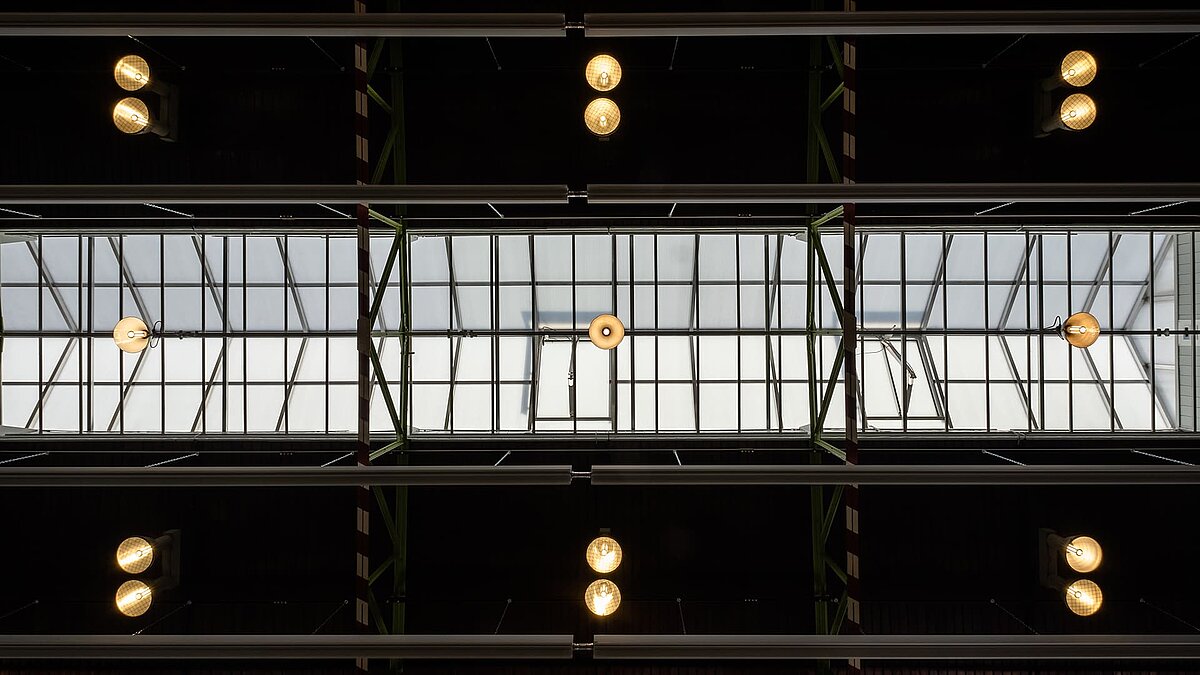 Interior view of the glass roof of the Zündmagnet event hall in Wurzen featuring modern lighting and industrial charm.