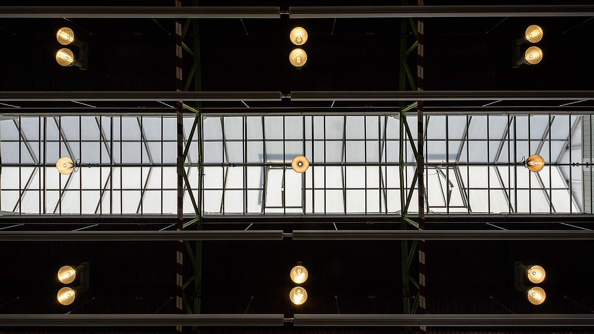 Interior view of the glass roof of the Zündmagnet event hall in Wurzen featuring modern lighting and industrial charm.