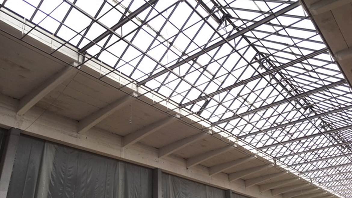 Glass roof structure with steel beams in an industrial hall