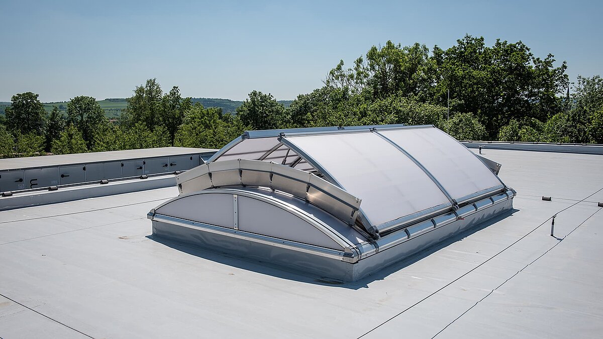 Roof view of the OWL climbing center featuring a large, arched skylight allowing natural daylight into the building.