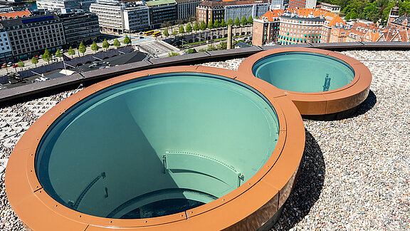 Two circular skylights on modern building roof overlooking urban surroundings