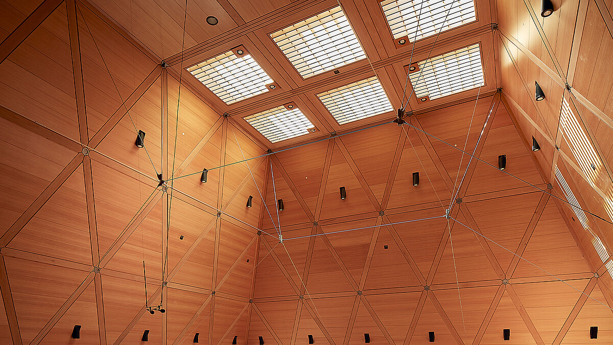 Große Halle mit Holzwänden und sechs Flachdach Fenstern in der Decke, die Licht in den Raum lassen.