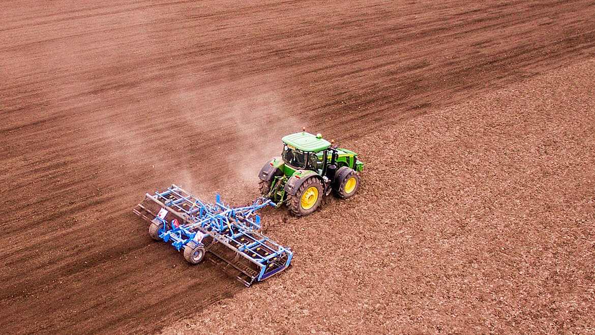 Tractor with plough working a field