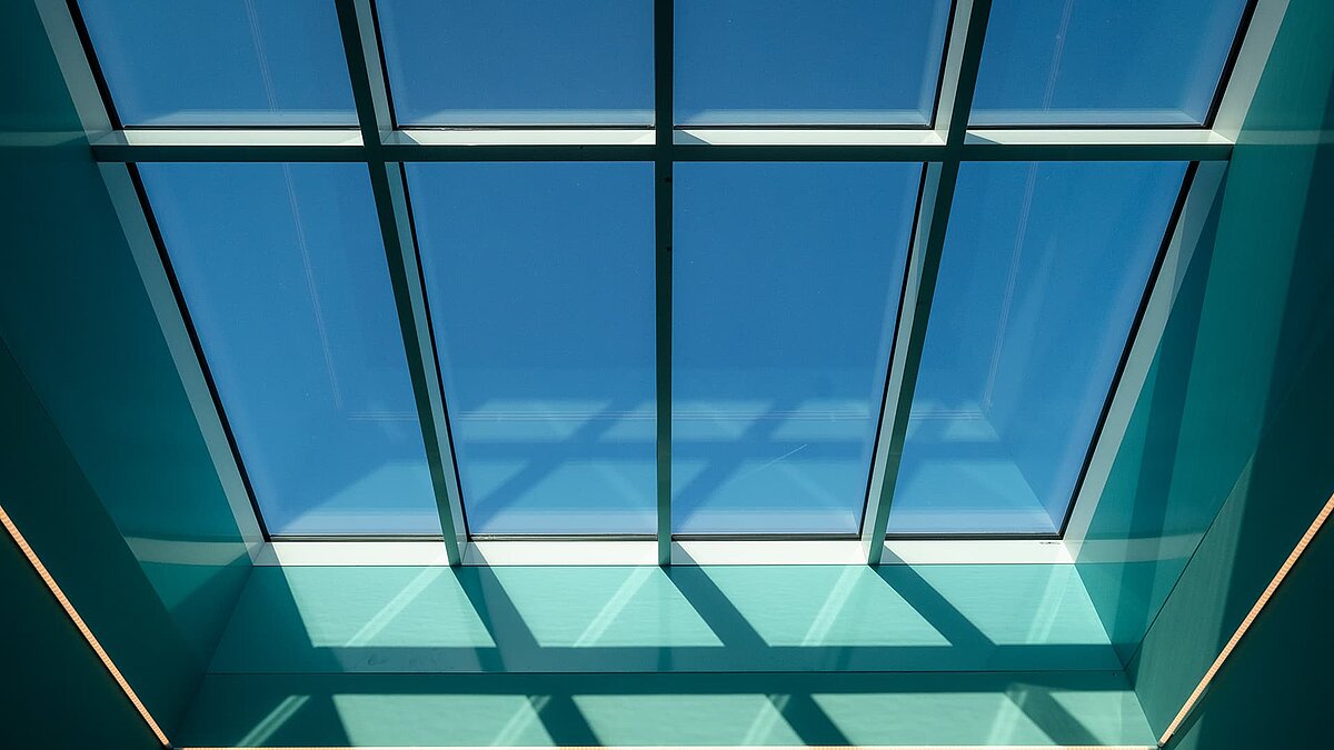 Interior of the ‘World of Kids’ kindergarten with modern LAMILUX glass roof and colourful design.