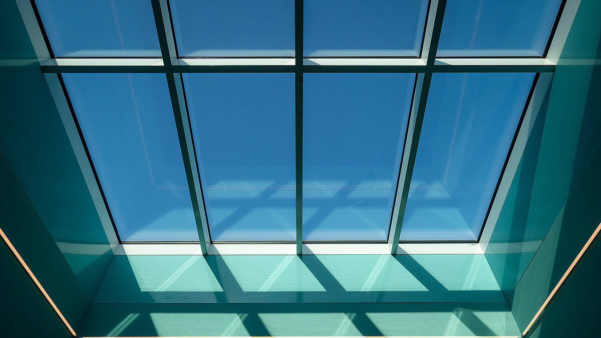Interior of the ‘World of Kids’ kindergarten with modern LAMILUX glass roof and colourful design.