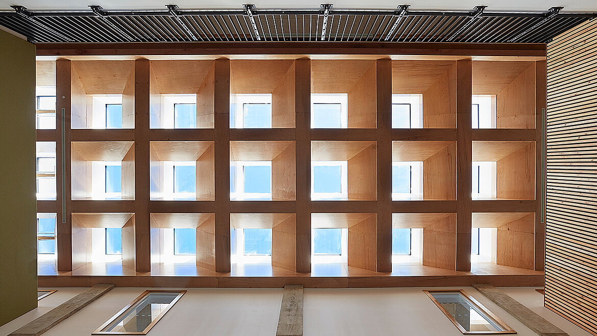 Modern wooden ceiling structure with square grid design and integrated skylights