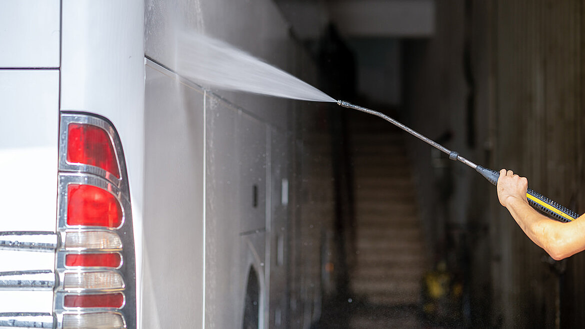 Man with steam jet washes bus side wall | insights by LAMILUX