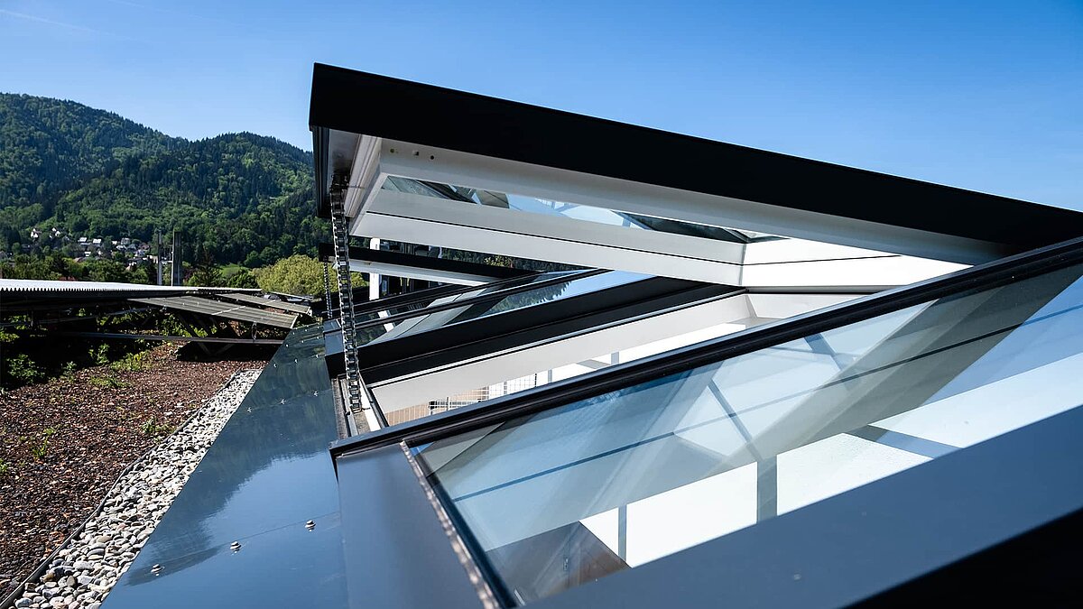 Residential building in Freiburg with modular glass roofs from LAMILUX, view of the open roof construction.