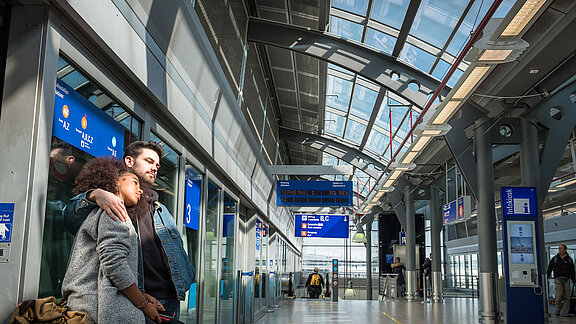 Ankunftshalle des Flughafen Frankfurt mit zwei Menschen im Vordergrund und dem Glasdach im Hintergrund