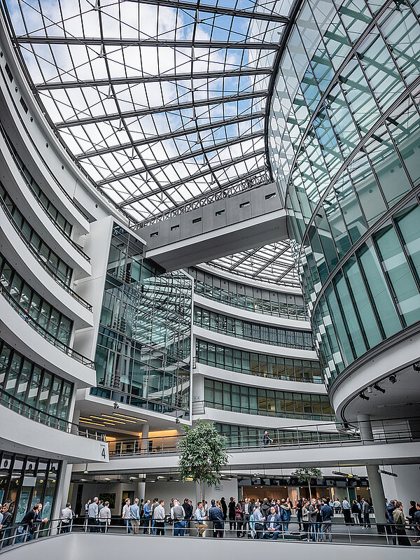 Spacious interior with glass roof and curved architecture at the BMW Group Research and Innovation Center FIZ.