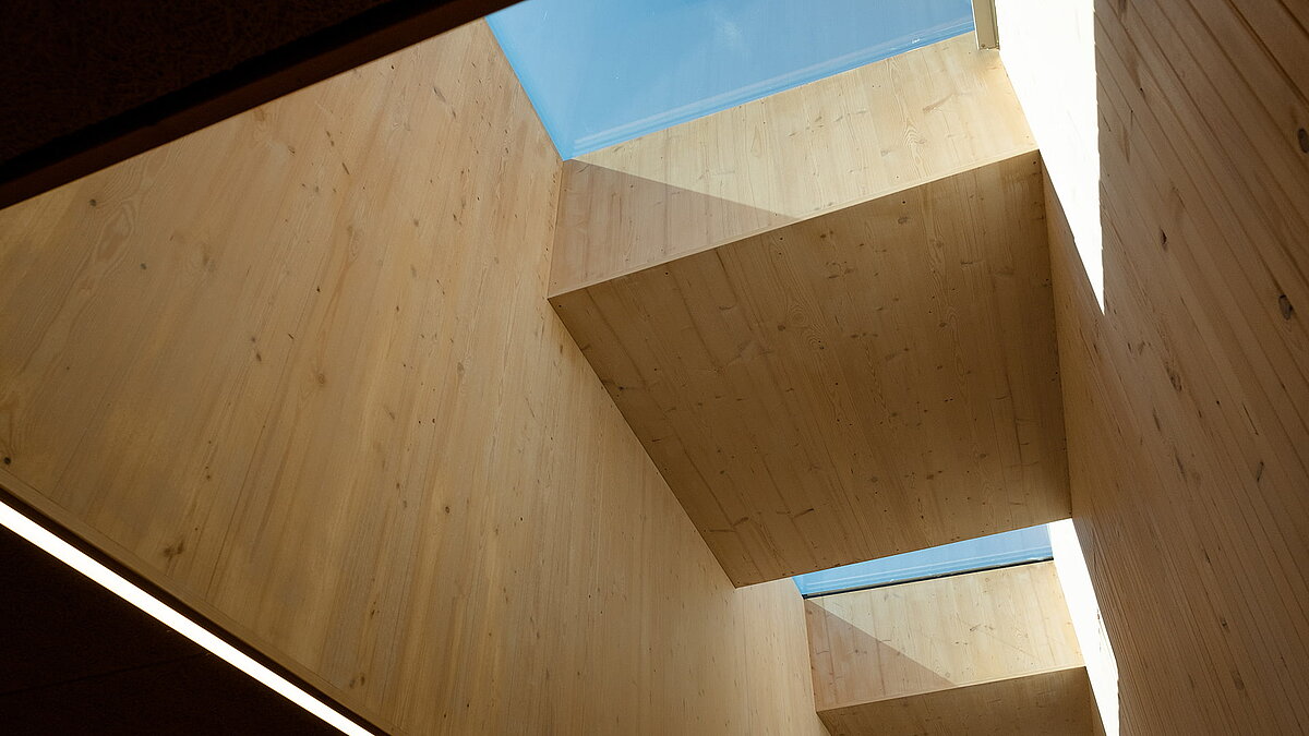 Light-filled wooden interior of the Waltenhofen daycare center with large skylights.