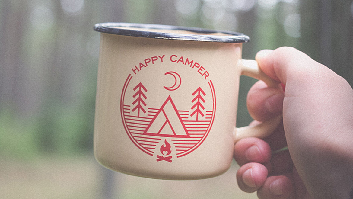 Hand holding cup in forest