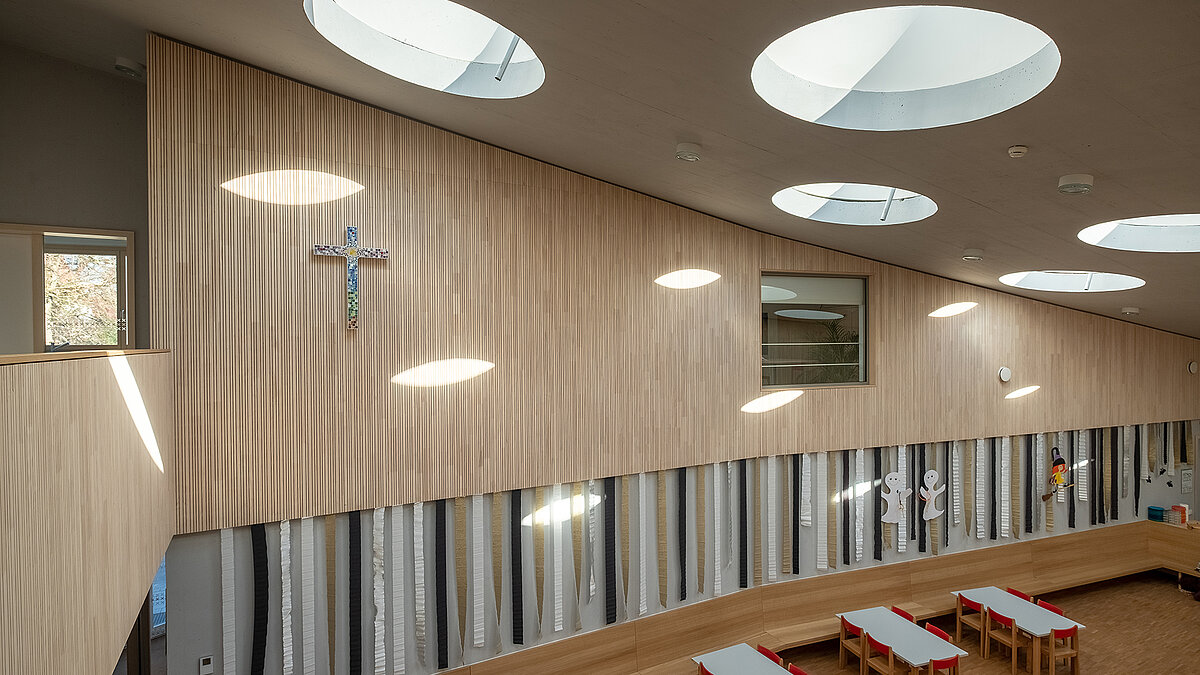 Interior view of St. Severin Kindergarten with round flat roof windows allowing natural daylight to enter.