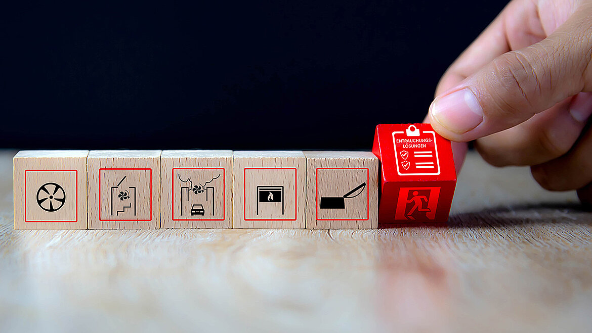 A hand turning a red cube featuring a checklist and emergency exit symbols