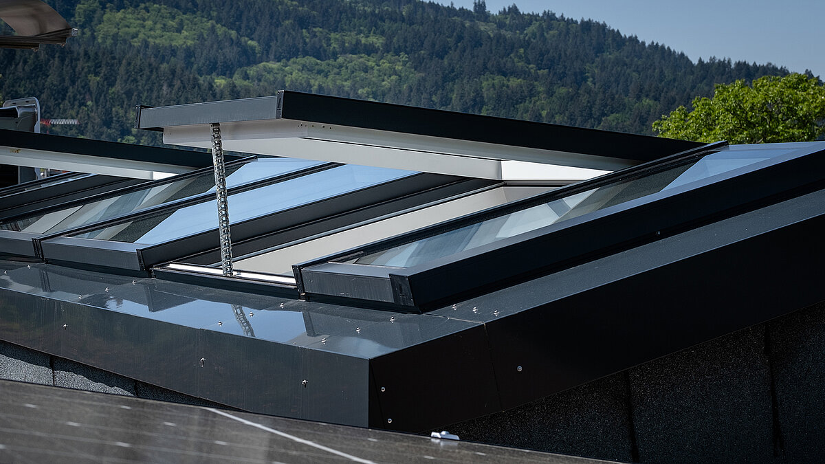 Close-up of a modular glass roof by LAMILUX in a residential building in Freiburg, partially opened for ventilation.