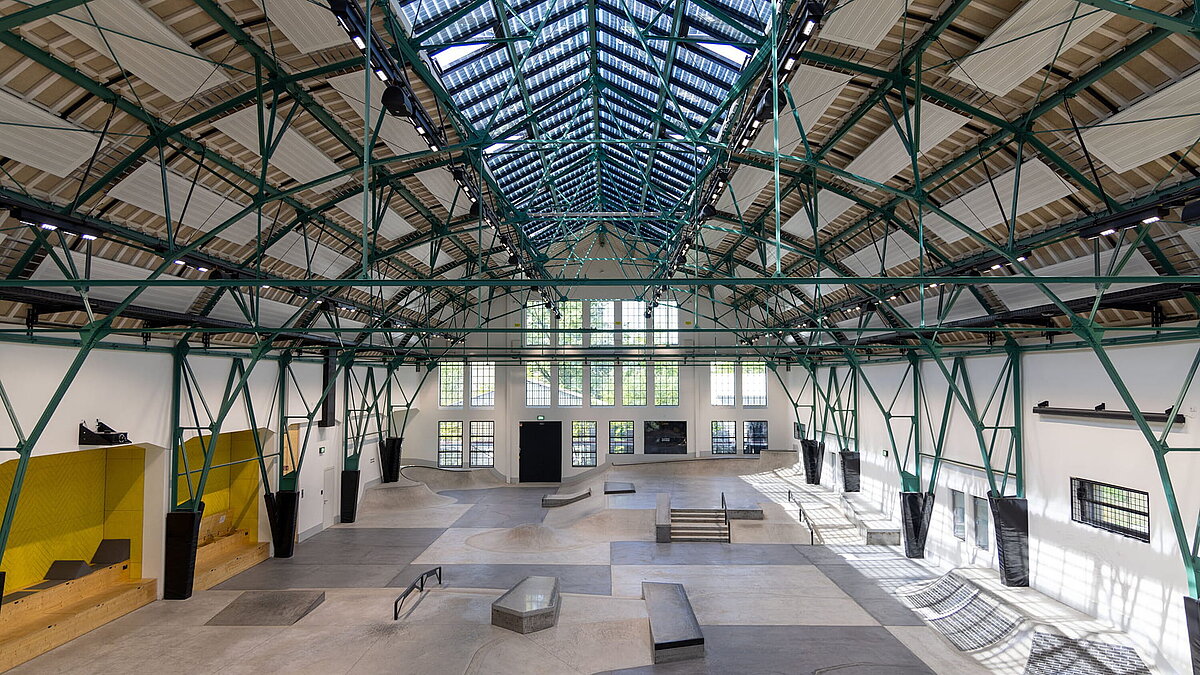 Interior of a former industrial hall with LAMILUX PR60 glass roof and integrated skatepark