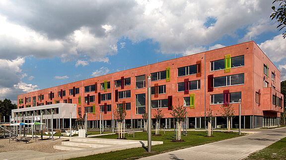 Exterior view of the Willibald-Gluck-Gymnasium in Neumarkt featuring colorful facade elements and modern design.