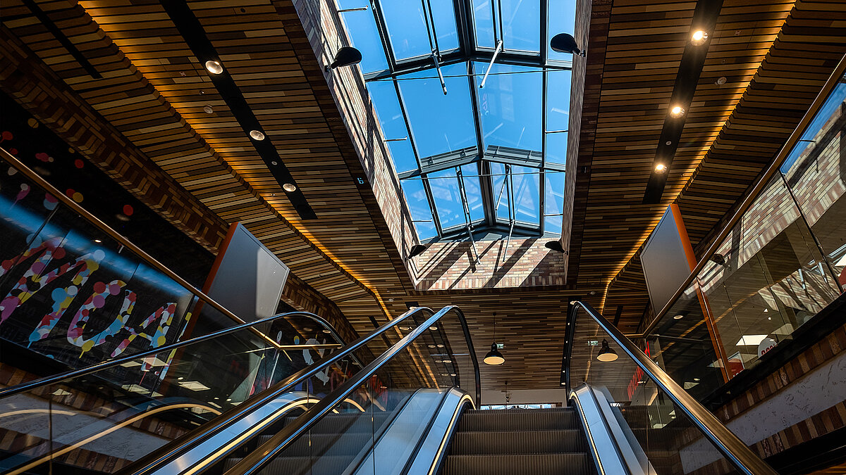LAMILUX glass roofs at Schultheiss Quartier in Berlin-Moabit, view from below showing the roof above an escalator.