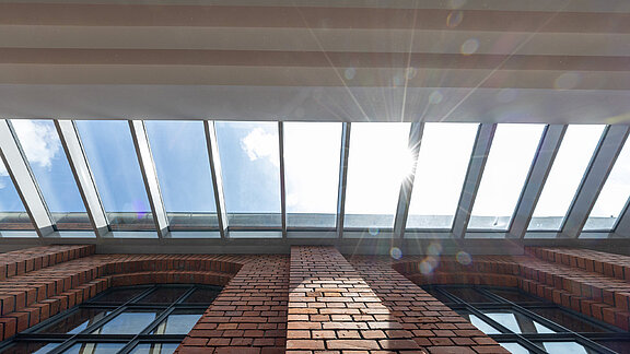 Glasdach über einem Backsteingebäude durch das Sonnenlicht fällt