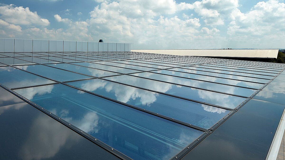 Glass roof of the commercial building in Milton Park, England, reflecting the sky and clouds on its surface.