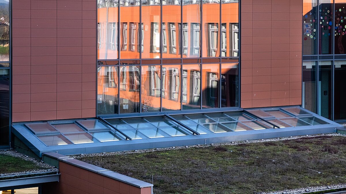 Rehau school center with LAMILUX PR60 glass roof above a green roof, providing natural daylight into the building.