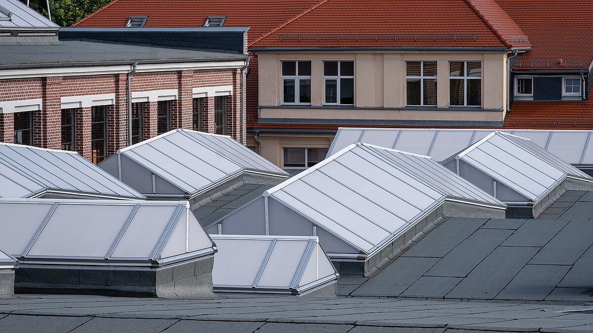 Roof view of the Zündmagnet event hall in Wurzen featuring modern white skylights