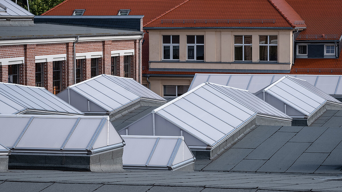 Roof view of the Zündmagnet event hall in Wurzen featuring modern white skylights