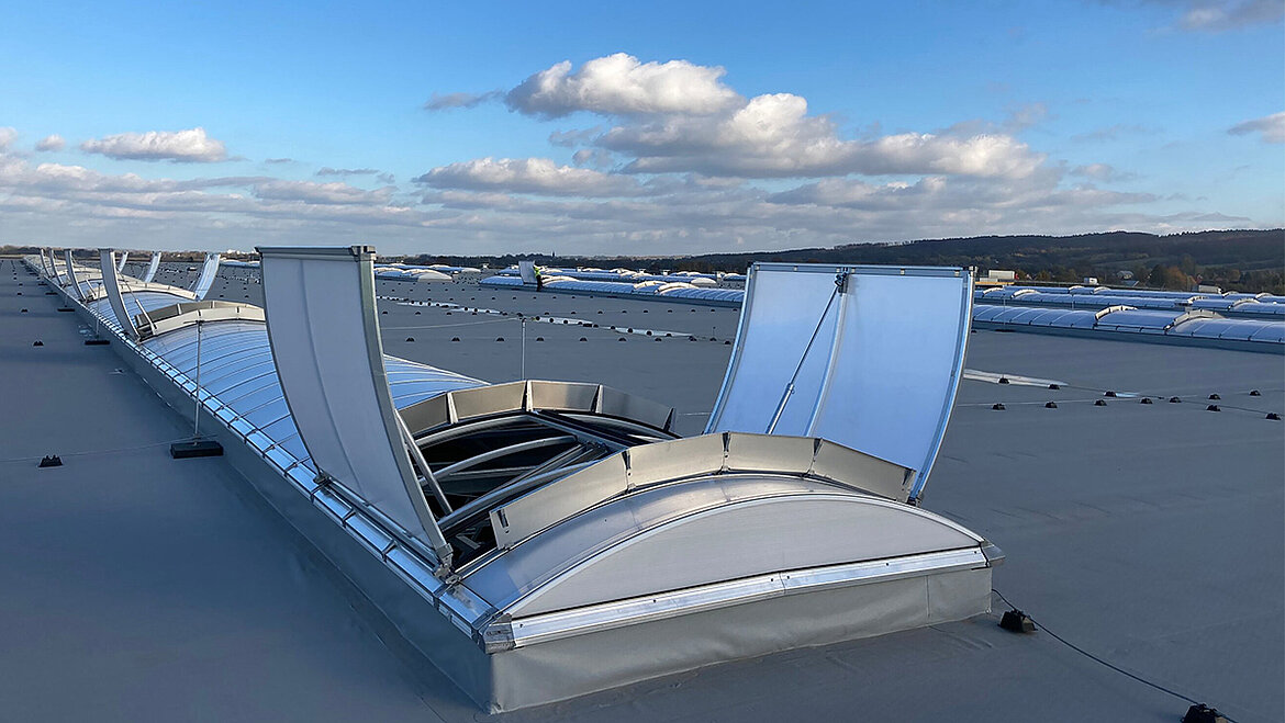 An open Continuous Rooflight on a large industrial flat roof beneath a blue sky