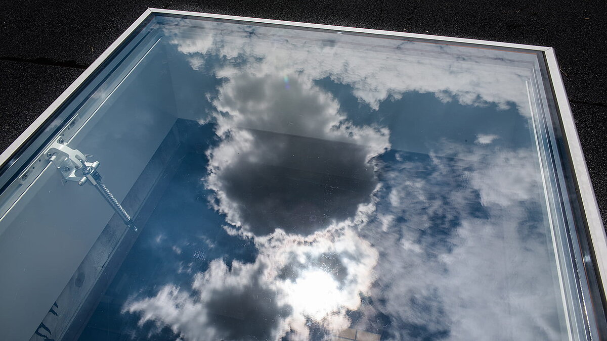 Reflection of clouds on a LAMILUX flat roof exit of a residential house in Korneuburg.