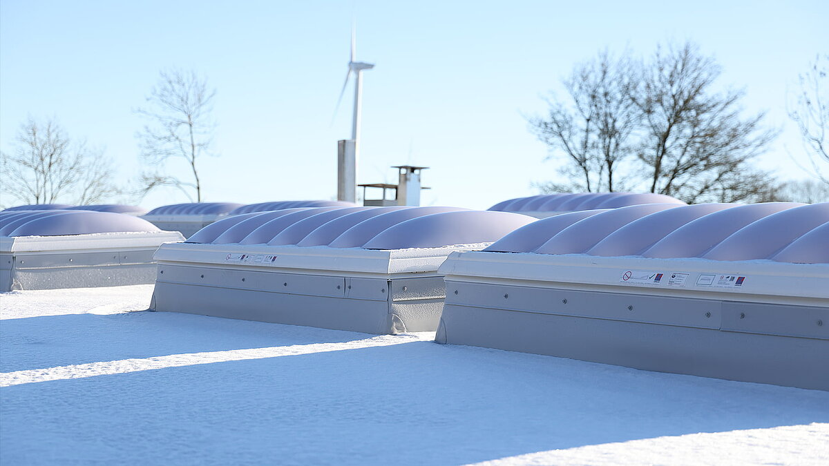 Several snow-covered skylight domes F100W on the roof of the ‘Ab in die Box’ building at Diemelsee.