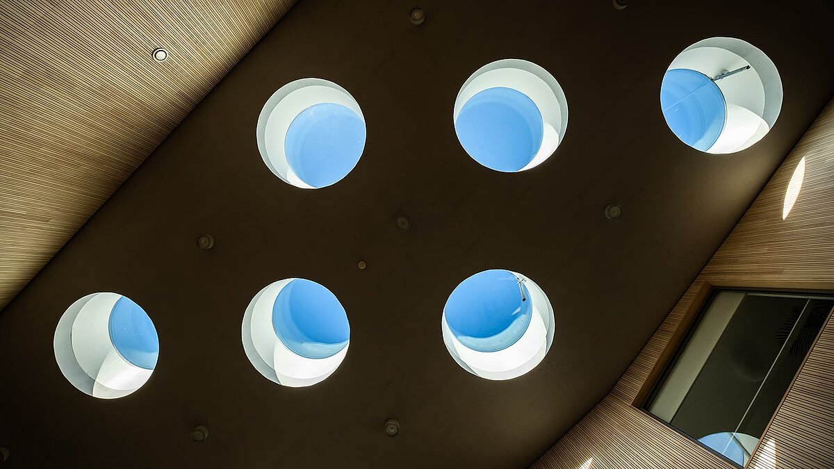 View of round flat roof windows in the St. Severin kindergarten, allowing natural light into the interior.