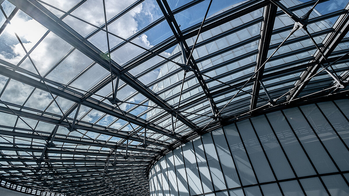  Modern glass roof structure of the BMW Group Research and Innovation Centre (FIZ) with a view of the sky.