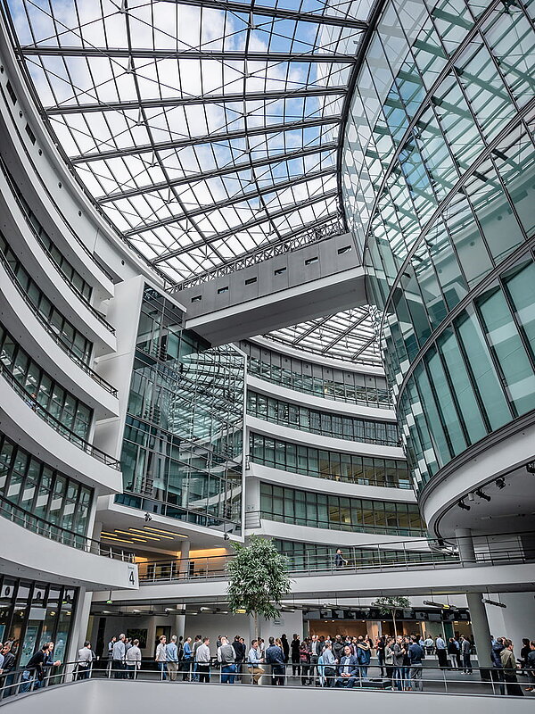 Spacious interior with glass roof and curved architecture at the BMW Group Research and Innovation Center FIZ.