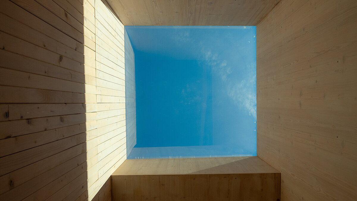Skylight in the Waltenhofen daycare center, where a rectangular roof window brings daylight onto the wooden-paneled walls.