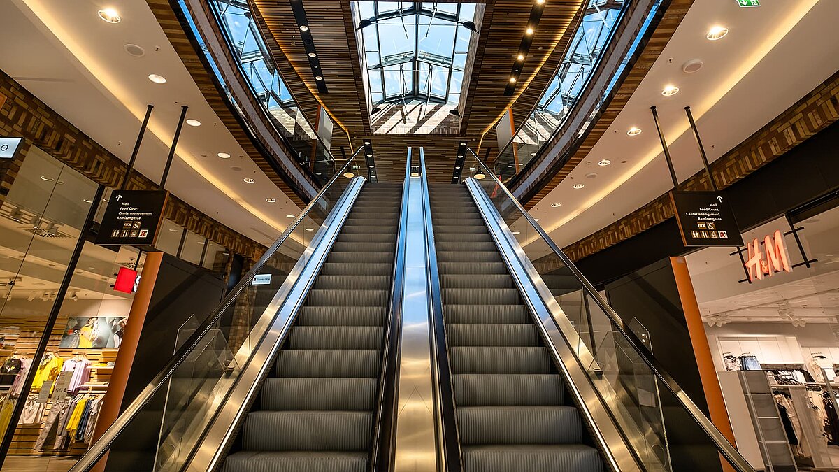 Escalators in the Schultheiss Quartier in Berlin-Moabit with a view of the LAMILUX glass roofs.