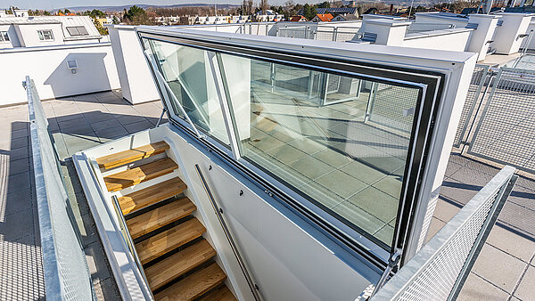 Flat roof exit by LAMILUX at a residential house in Korneuburg, featuring a modern staircase and glazing with a view of the surroundings.
