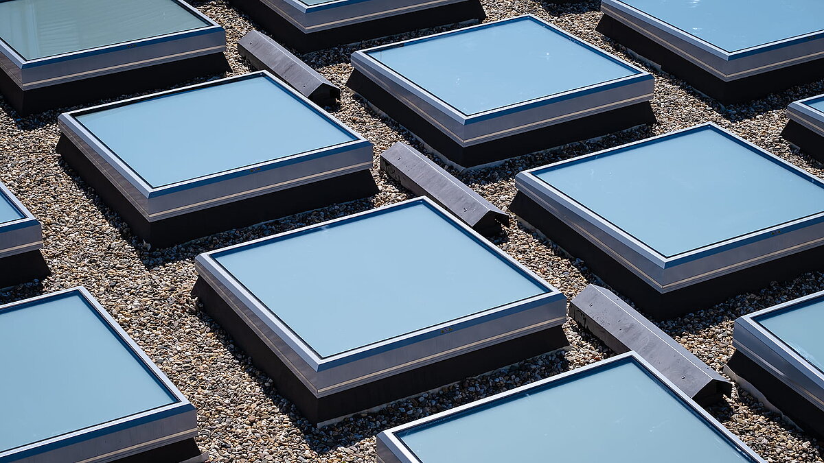 Close-up of the square skylights on the roof of the Weiden district court, surrounded by gravel.
