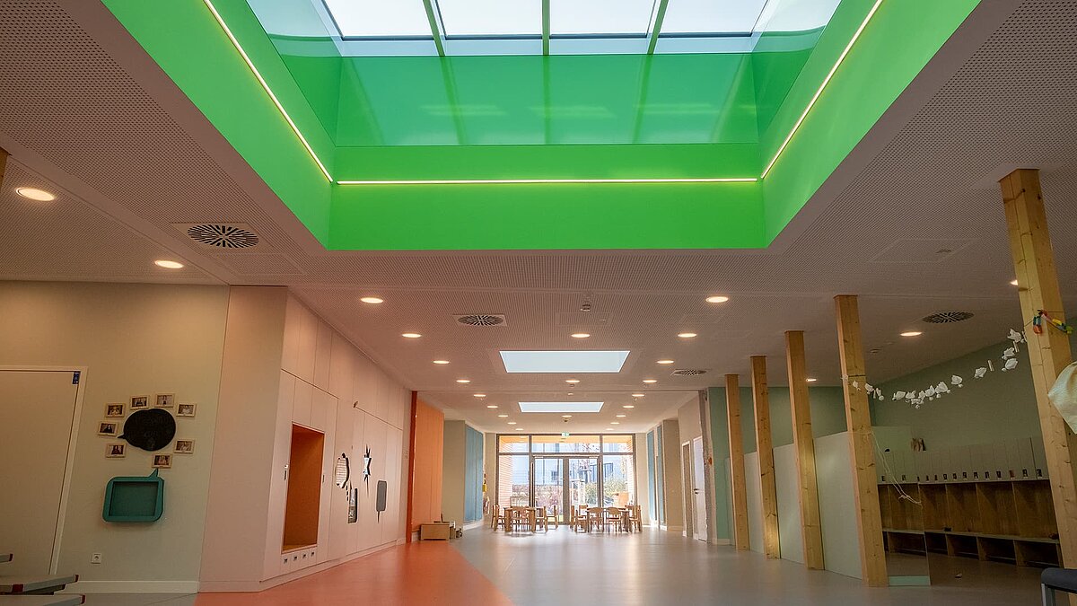 Interior view of the "World of Kids" kindergarten featuring LAMILUX flat roof window FE 3° and PR60 glass roof, providing natural daylight.