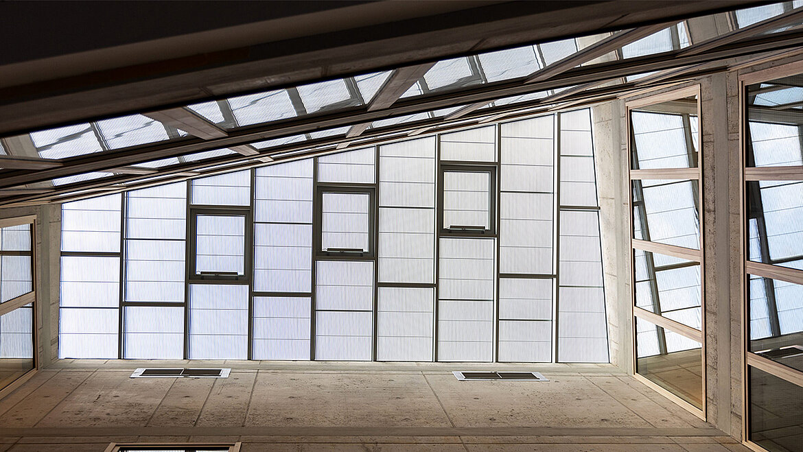 Modern glass facade with structured panels and integrated ventilation windows