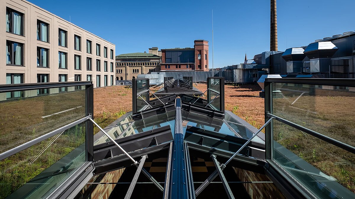 LAMILUX PR60 glass roof at Schultheiss Quartier with open ventilation elements on green roof.