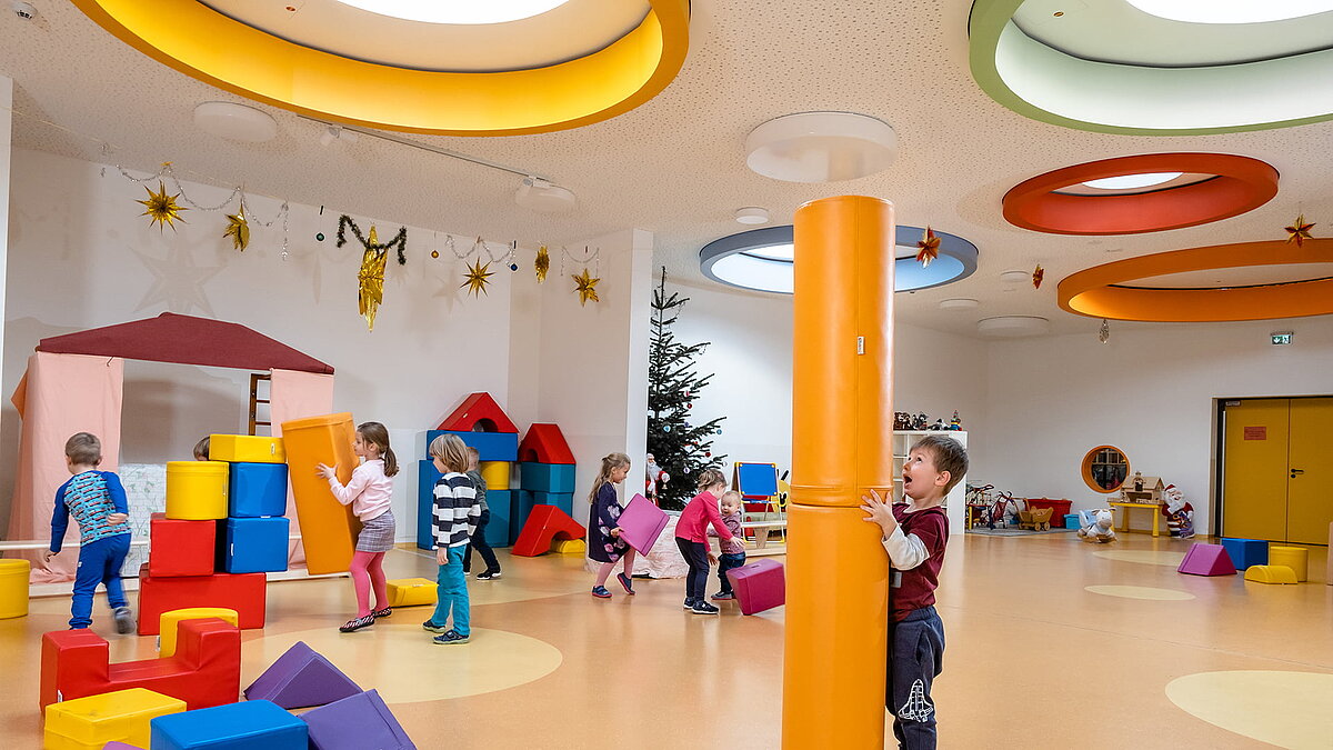Children playing with colorful building blocks in the "Glückliche Zukunft" daycare center in Sömmerda, beneath colorful round skylights.