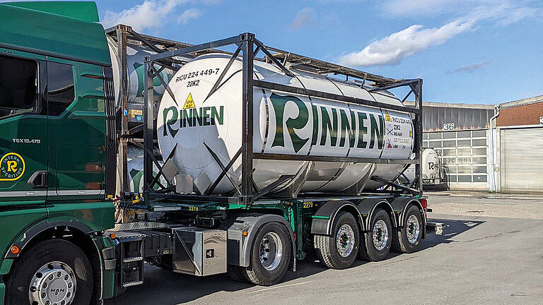 White ISO tank container on a green truck labeled "RINNEN" with GRP tank cladding