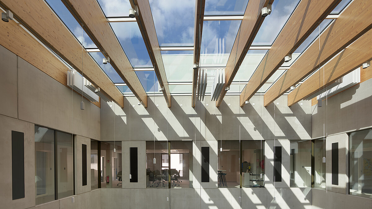 Atrium with wooden slat canopy and large glass roof for natural daylight