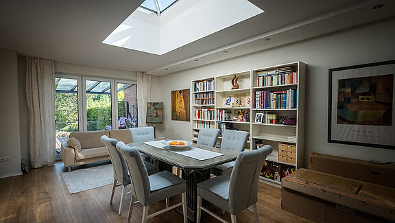 Dining area in a residential house in Hamburg with a LAMILUX FW flat roof window, creating a bright and open atmosphere.