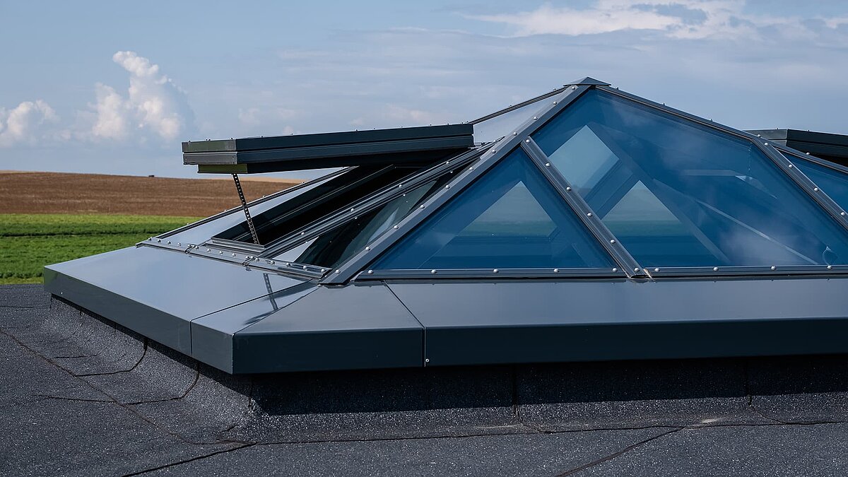 Modern glass pyramid on the flat roof of a single-family home in Wichmannsdorf with an open ventilation window.