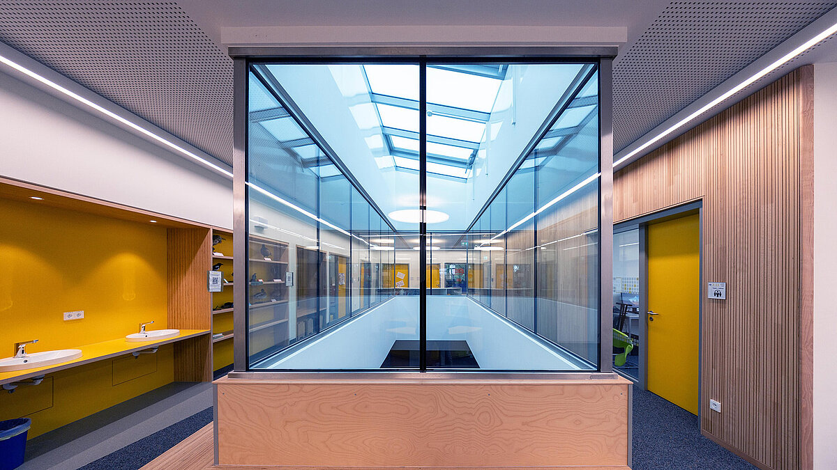 Glass-covered atrium in Burgebrach school center with LAMILUX glass roof PR60.