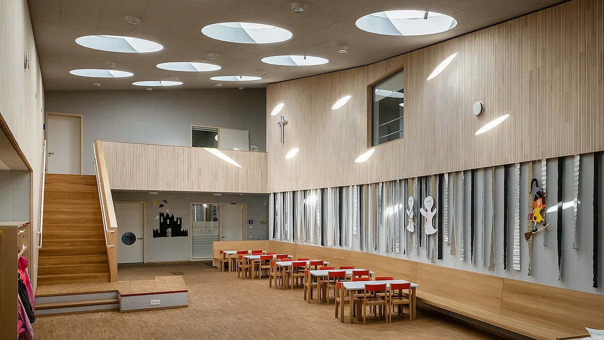 Interior of St. Severin kindergarten with round flat roof windows allowing natural light into the space.